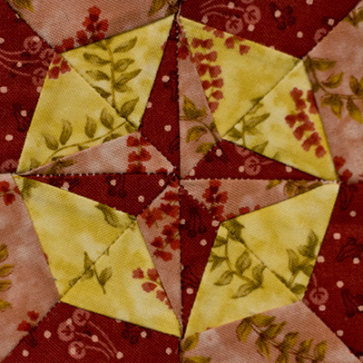 Compass Rose Miniature Block size 2in pieced with red and yellow fabrics